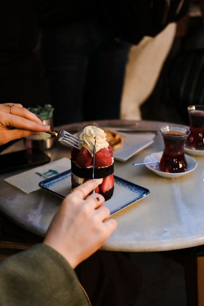 Enjoy a delicious dessert with strawberries and whipped cream at a cozy table in İstanbul, Türkiye.