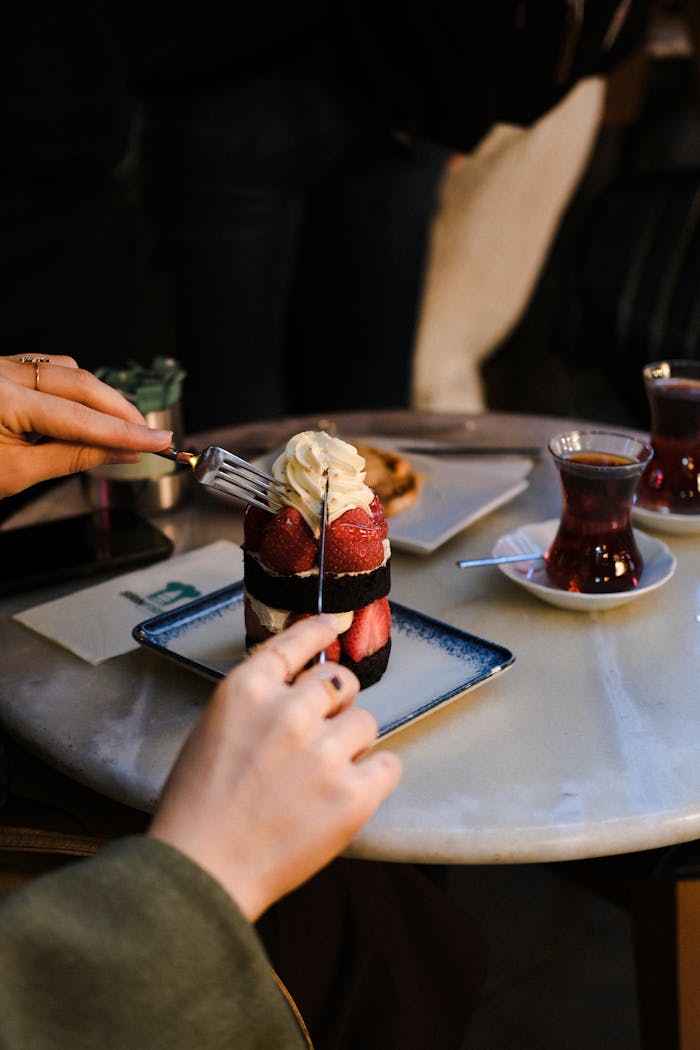 Enjoy a delicious dessert with strawberries and whipped cream at a cozy table in İstanbul, Türkiye.